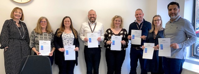 Photo of settle leadership team holing their personal EDI commitment pledges